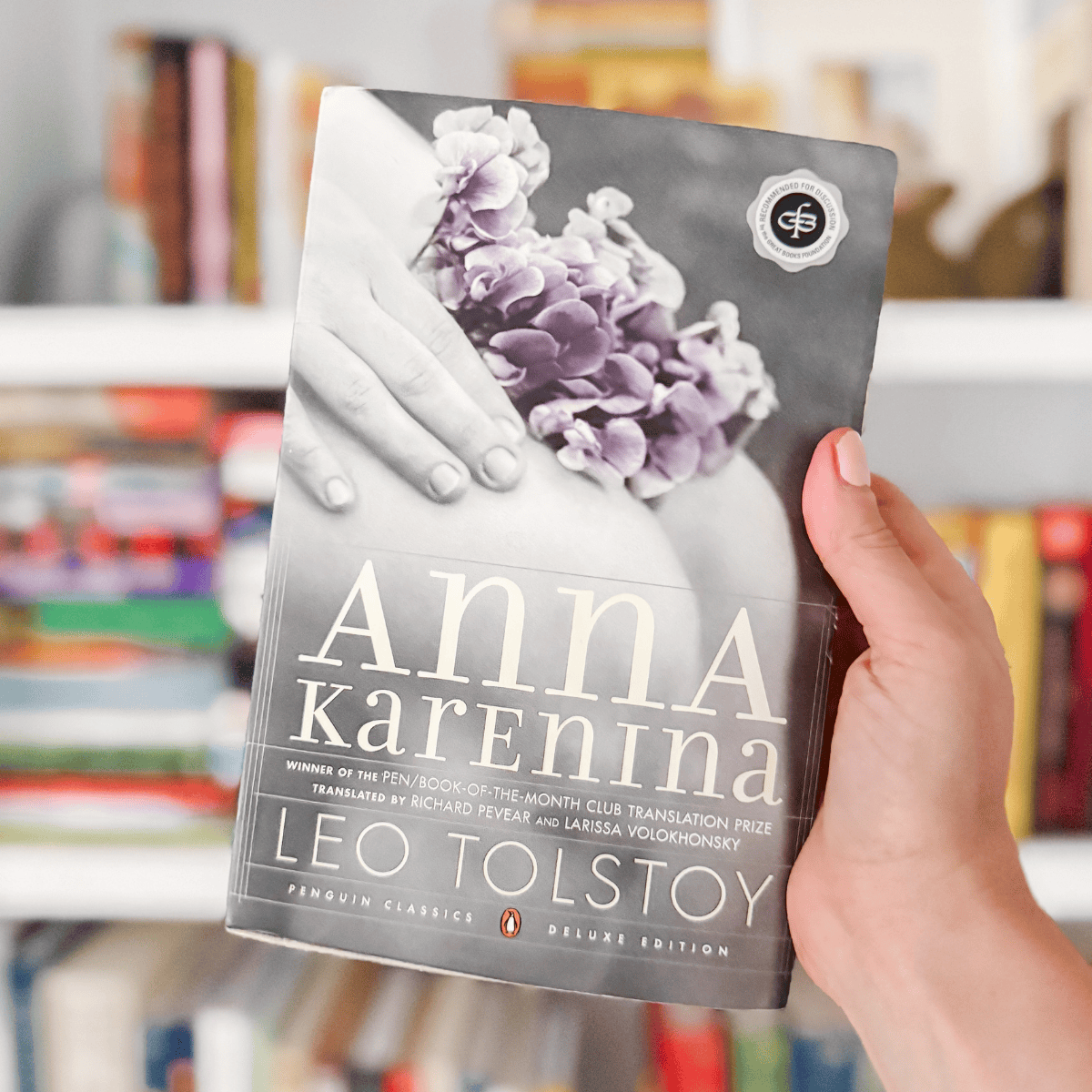 Anna Karenina by Leo Tolstoy in front of a bookshelf.