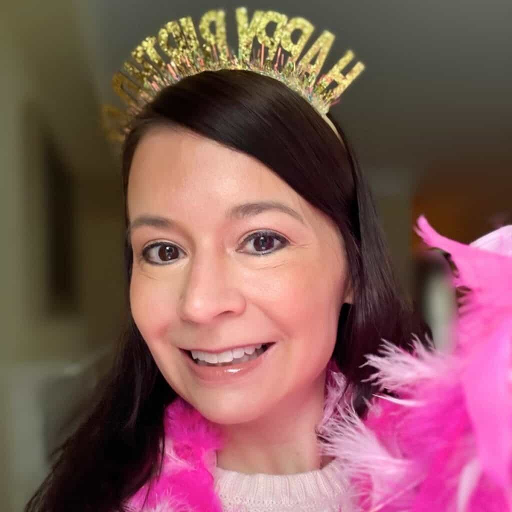 woman dressed as Rory Gilmore in her birthday episode with a pink boa and tiara.